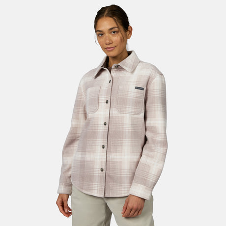 [Model is wearing size S.] A woman modeling a Free Country long-sleeve button-up shirt in a light beige and pinkish-taupe plaid pattern, paired with light khaki pants, against a solid light gray background.