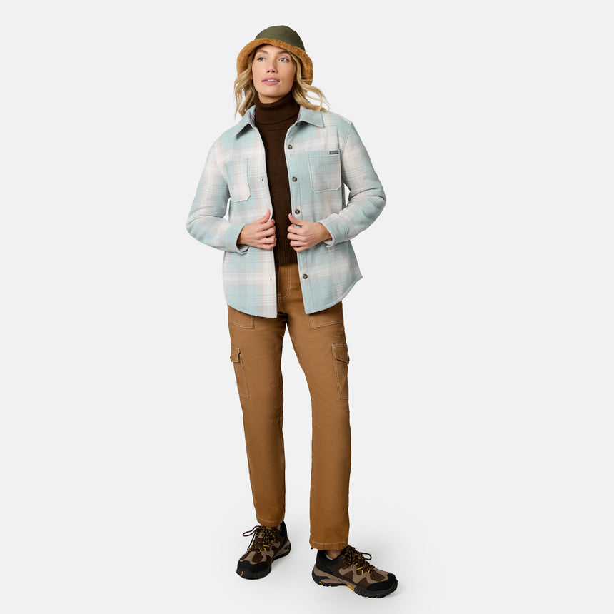 [Model is wearing size S.] A woman modeling a light blue and white plaid button-up shirt jacket over a dark brown turtleneck, paired with brown cargo pants, hiking boots, and a green bucket hat, against a plain white studio background.