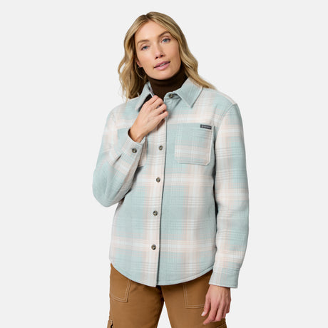 [Model is wearing size S.] A woman modeling a light blue and white plaid button-up overshirt over a dark brown turtleneck sweater and brown cargo pants, set against a plain light gray studio background.