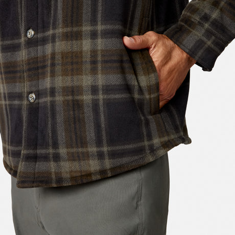A person is shown from the lower torso down, wearing Free Country’s Men’s Chill Out Fleece Shirt Jacket and gray pants, with their right hand slipped into the jacket’s side pocket against a plain background.