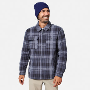 [Model is wearing size M.] A man wearing a navy blue beanie and a navy and gray plaid zip-up flannel shirt jacket, paired with beige pants, against a light gray background.