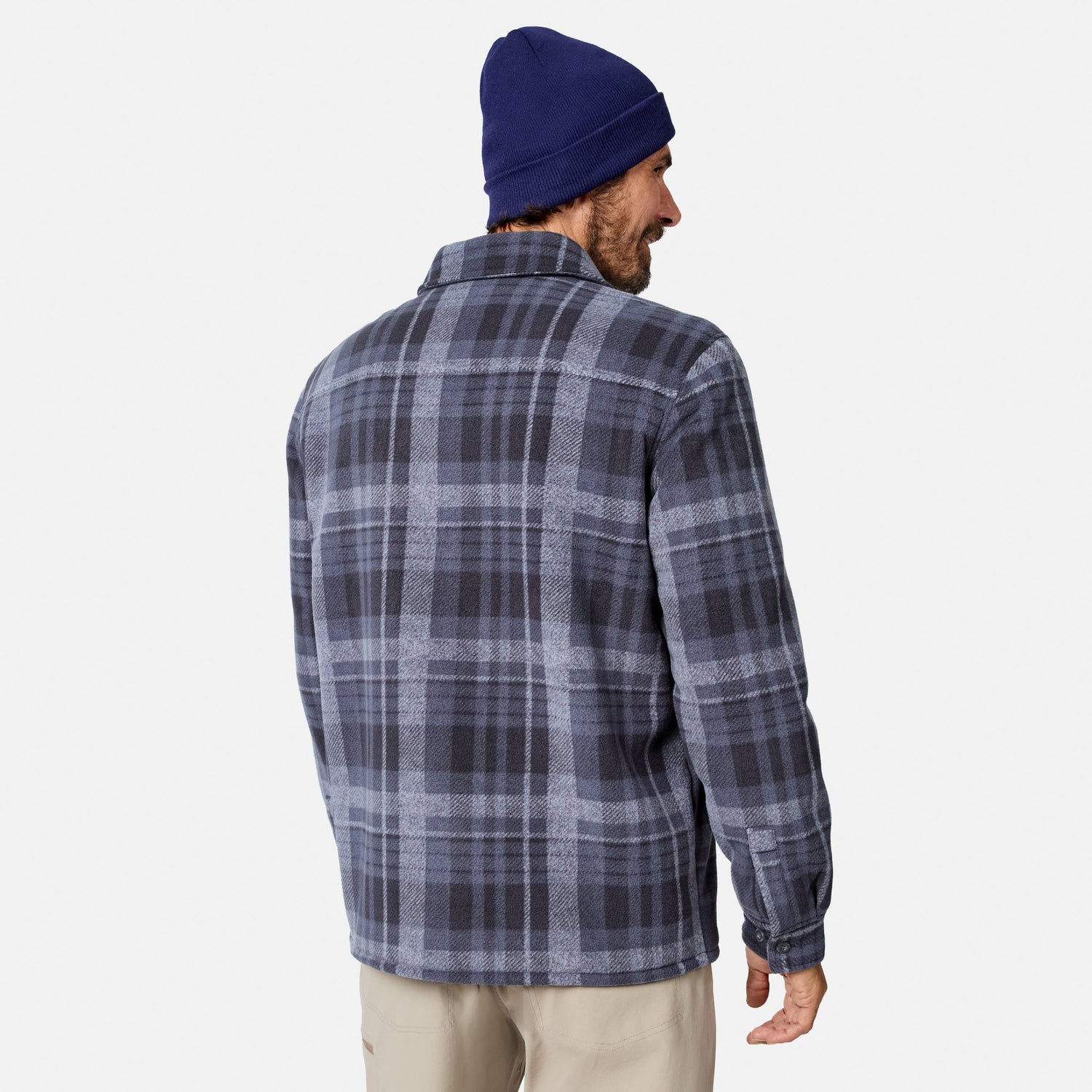 [Model is wearing size M.] A man wearing a navy blue beanie and a navy and gray plaid flannel shirt, shown from a back-three-quarter view against a light gray studio background.