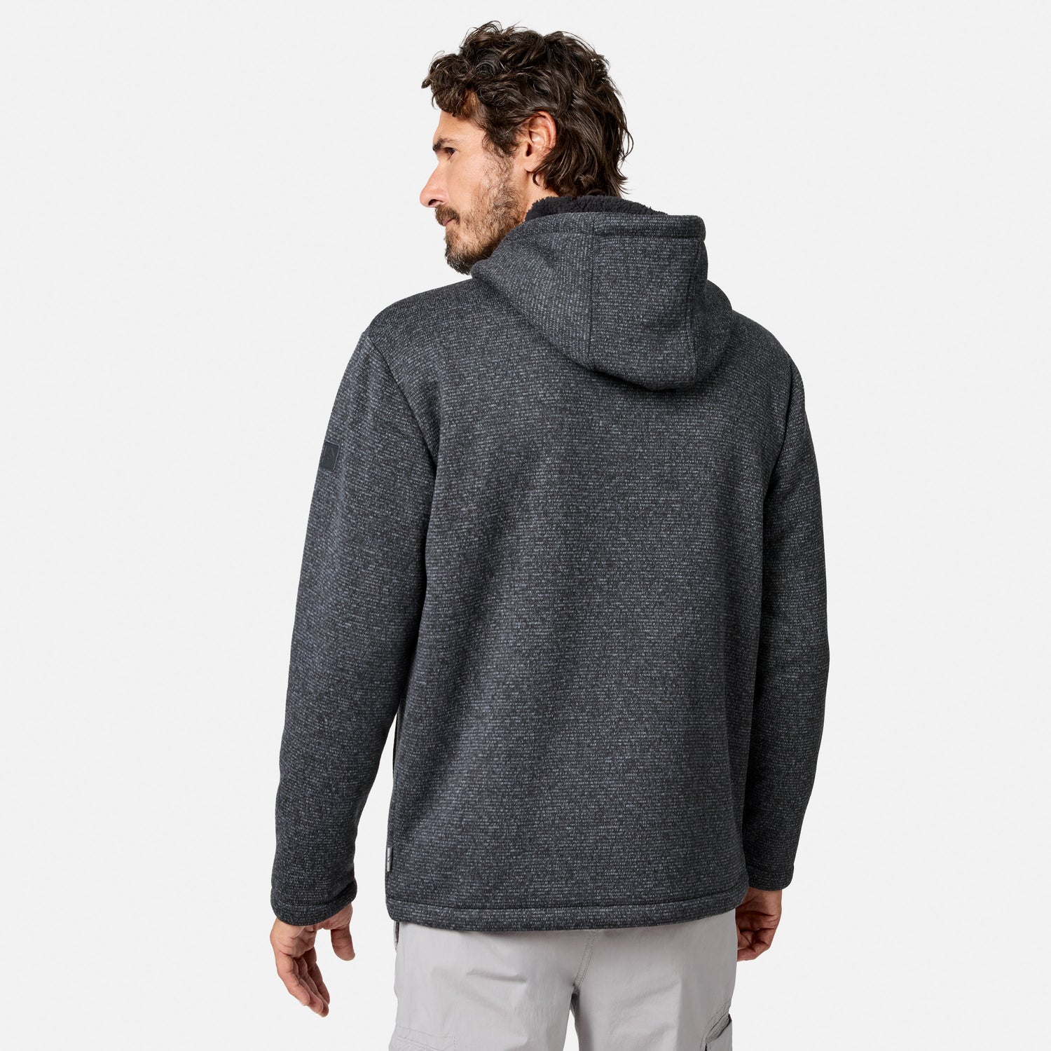 [Model is wearing size M.] A man with brown hair and a beard is wearing a dark gray Free Country Men’s Mountain Fleece Jacket and light gray pants, standing against a plain white background with his back to the camera.