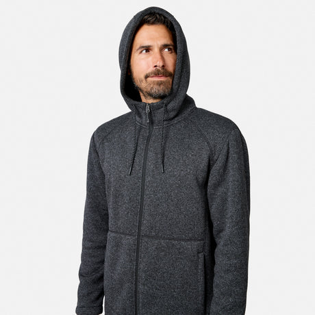 [Model is wearing size M.] A bearded man wearing a dark gray Men’s Mountain Fleece Jacket by Free Country with a zip-up hood looks slightly to the side against a plain white background.