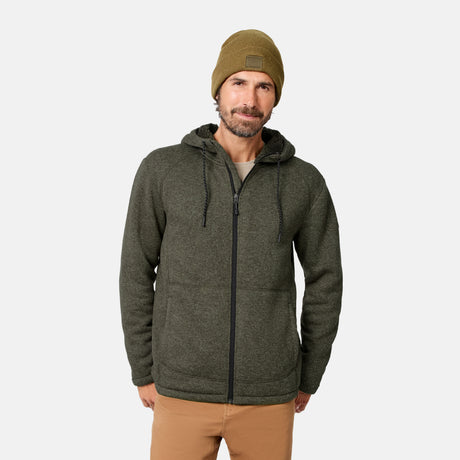 [Model is wearing size M.] A man wearing a mushroom-colored Men’s Mountain Fleece Jacket by Free Country, paired with tan pants and an olive beanie, stands against a plain white background, looking at the camera with a slight smile. This lightweight sweater fleece jacket provides warmth and effortless comfort for everyday wear.