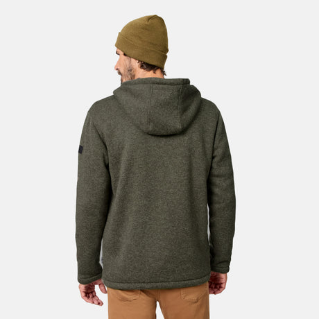 [Model is wearing size M.] A man wearing a green Men’s Mountain Fleece Jacket by Free Country, a khaki beanie, and tan pants stands facing away against a plain light background.