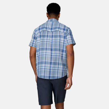 [Josiah is 6'3" wearing a size Medium.] Man wearing the Free Country Men's Excursion Short Sleeve Poplin Shirt in Denim Plaid, size M, made from lightweight moisture wicking polyester fabric featuring vent at the back, full button down front, and a stand collar, styled with navy shorts #color_ denim-plaid
