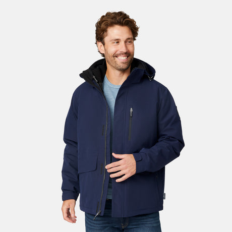 [Matt is 6'2" wearing size M.] Man wearing Free Country Men's Ski Patrol 3-in-1 Systems Jacket in dark navy with a full front zipper opening, an outer jacket for wind and cold weather, an inner puffer jacket, and wind resistant and water resistant stretch performance fabric, light grey background. Perfect men’s jacket for winter weather.