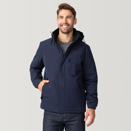 [Matt is 6'2" wearing size M.] Man wearing Free Country Men's Ski Patrol 3-in-1 Systems Jacket in dark navy with a full front zipper opening, an outer jacket for wind and cold weather, an inner puffer jacket, and wind resistant and water resistant stretch performance fabric, light grey background. Perfect men’s jacket for winter weather.