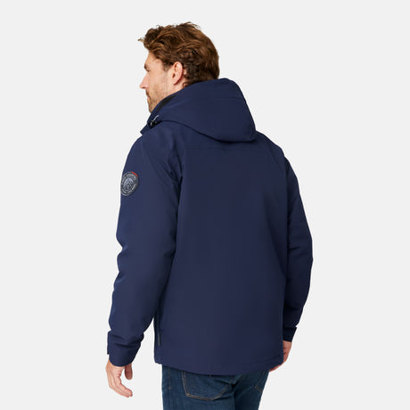 [Matt is 6'2" wearing size M.] Man wearing Free Country Men's Ski Patrol 3-in-1 Systems Jacket in dark navy with a full front zipper opening, an outer jacket for wind and cold weather, an inner puffer jacket, and wind resistant and water resistant stretch performance fabric, light grey background. Perfect men’s jacket for winter weather.