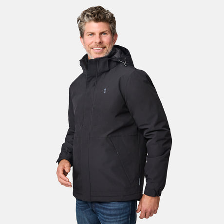 [Kolby is 6’2” wearing size M.] Men’s Free Country black zip-front jacket with hood, zippered side pockets, and subtle logo on the left chest—layered over a green crewneck tee and paired with blue jeans for versatile, cool-weather wear.