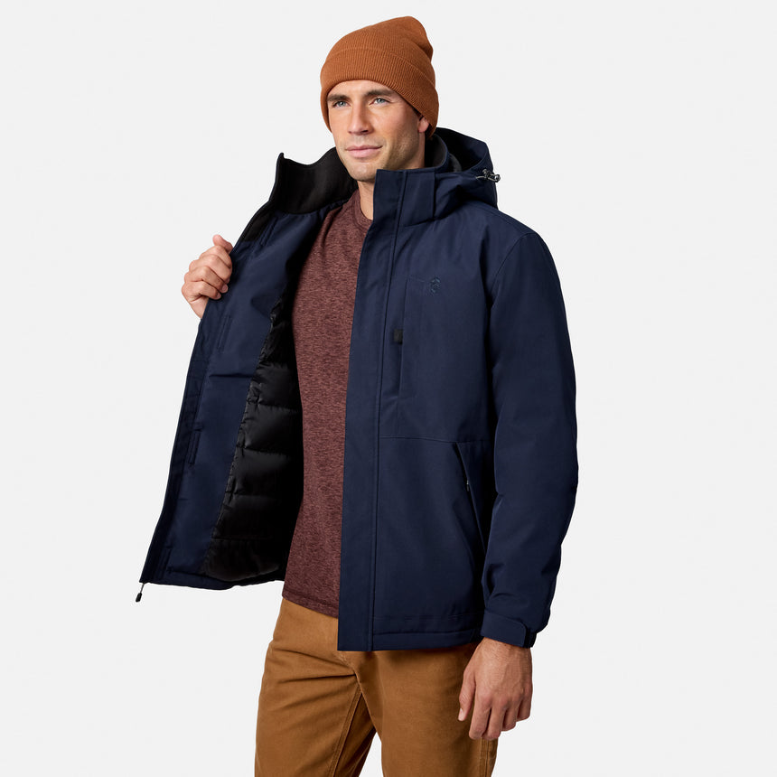 Man in navy Denali insulated jacket open at the front showing the black lining and burgundy shirt with a brown beanie