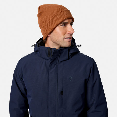 Close up of brown knit beanie on a male model wearing a navy Denali insulated jacket