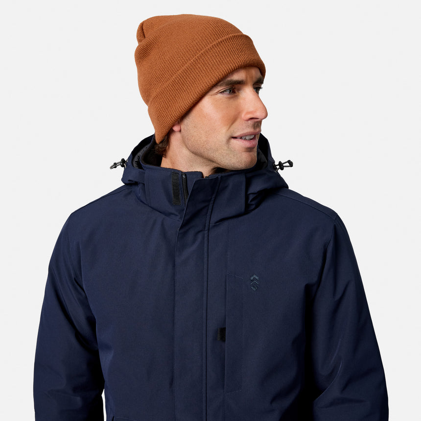 Close up of brown knit beanie on a male model wearing a navy Denali insulated jacket