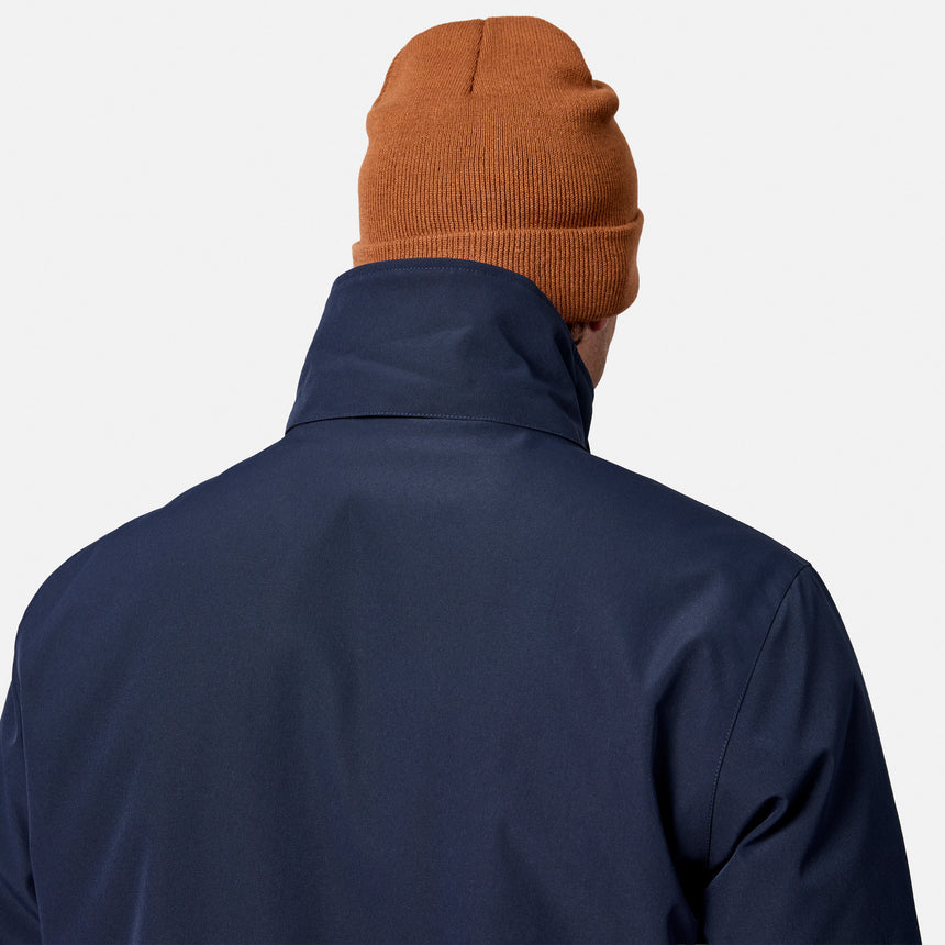 [Model is wearing size M.] Back view of a person wearing a navy blue jacket and an orange-brown knit beanie against a light gray background.