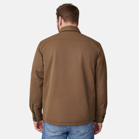 [Joe is 6'0" wearing size M.] Men’s Free Country brown canvas jacket layered over a white crewneck tee and blue jeans—features zippered chest pockets and left-side logo patch for rugged outdoor appeal and everyday versatility.