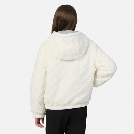 A model viewed from the back wearing a cream-colored, diamond-quilted fleece hooded jacket and black pants against a light gray studio background.