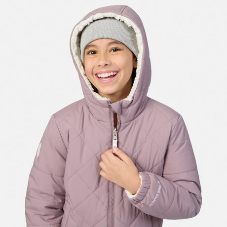 A smiling child wearing a dusty purple quilted winter jacket with a white sherpa-lined hood and a gray knit beanie, shown against a plain light gray background.
