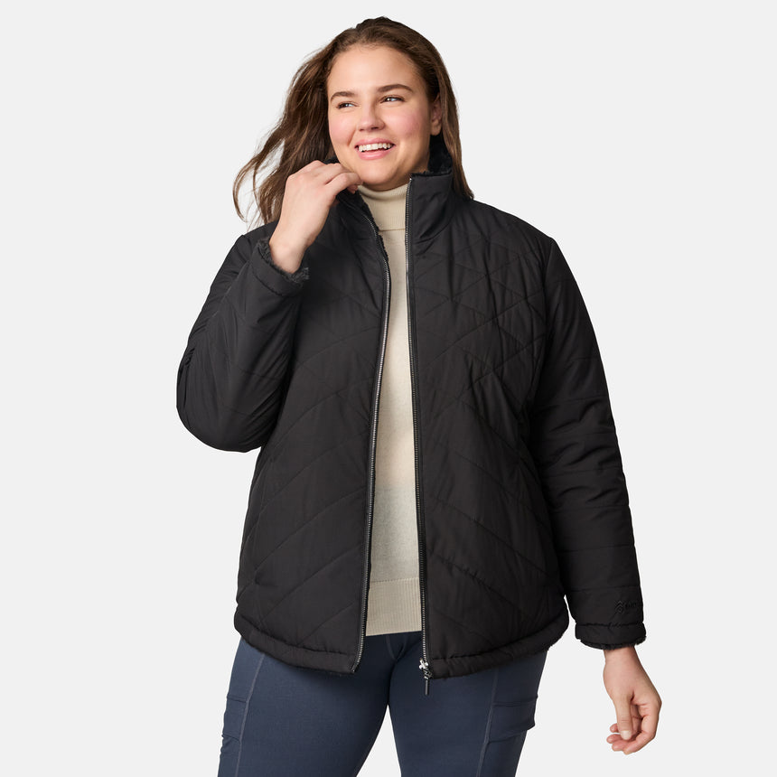 [Karissa is 5'9.5" wearing size 1X.] Woman wearing a black quilted reversible Free Country jacket on a white background