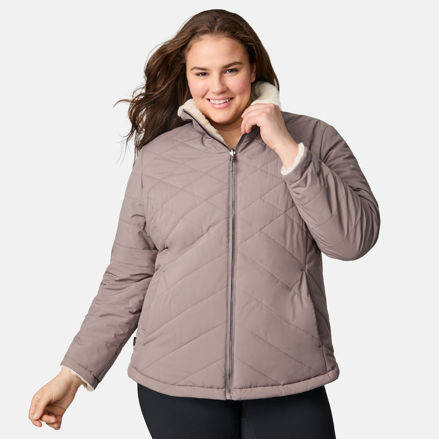 [Karissa is 5'9.5" wearing size 1X.] Woman wearing a brown quilted reversible Free Country jacket on a white background