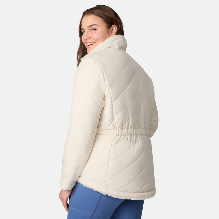 [Karissa is 5'9.5" wearing size 1X.] Woman wearing a cream quilted reversible Free Country jacket on a white background