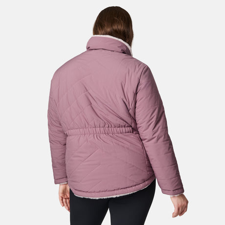 A person faces away from the camera, wearing the Women's Plus Size Cirrus Quilted Reversible Jacket by Clearance in light purple. Made with recycled polyester, it features an elastic waistband and high collar against a plain white background.