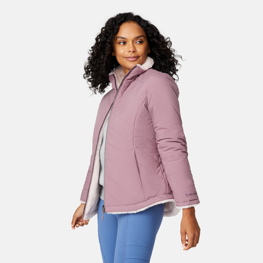 [Angelique is 5'10" wearing size S.] Woman wearing a pink quilted reversible Free Country jacket on a white background