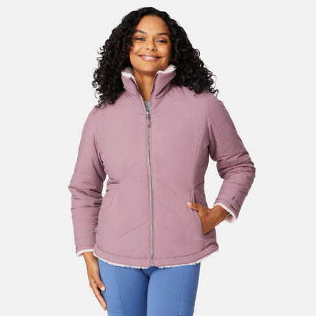 [Angelique is 5'10" wearing size S.] Woman wearing a pink quilted reversible Free Country jacket on a white background