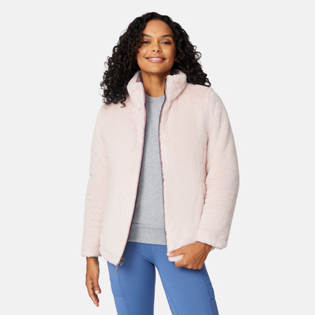 [Angelique is 5'10" wearing size S.] Woman wearing a pink quilted reversible Free Country jacket on a white background