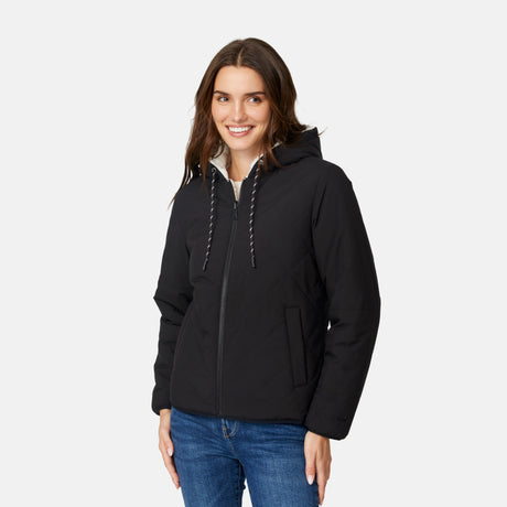 [Jessica is 5'9.5" wearing size S.] Free Country women’s black reversible quilted jacket with hood and patterned drawstrings, featuring zip-front closure and dual side pockets—styled with blue jeans for versatile, cold-weather wear.