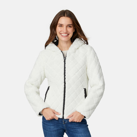 [Jessica is 5'9.5" wearing size S.] Free Country women’s black reversible quilted jacket with hood and patterned drawstrings, featuring zip-front closure and dual side pockets—styled with blue jeans for versatile, cold-weather wear.