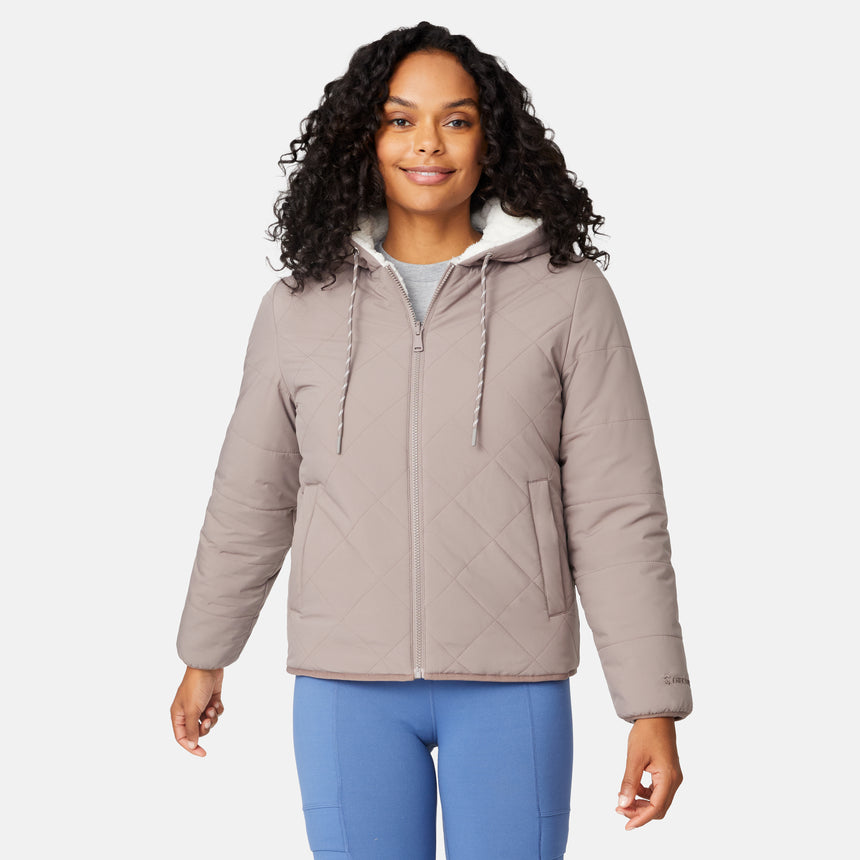 [Angelique is 5'10" wearing size S.] Light brown quilted reversible jacket with fleece-lined hood, zip front, and pockets; worn over grey shirt and blue pants.