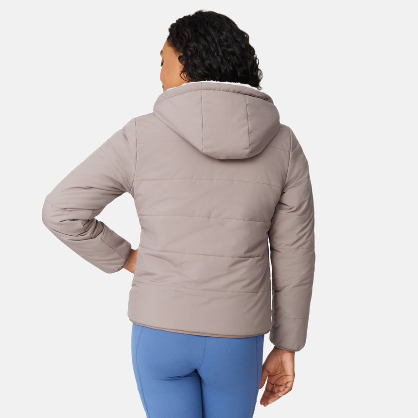 [Angelique is 5'10" wearing size S.] Light brown quilted reversible jacket with fleece-lined hood, zip front, and pockets; worn over grey shirt and blue pants.