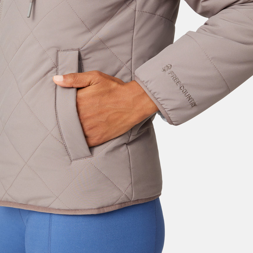 [Angelique is 5'10" wearing size S.] Light brown quilted reversible jacket with fleece-lined hood, zip front, and pockets; worn over grey shirt and blue pants.
