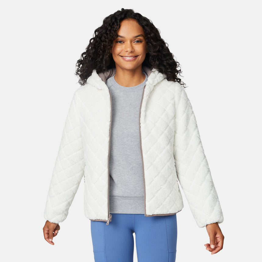 [Angelique is 5'10" wearing size S.] Light brown quilted reversible jacket with fleece-lined hood, zip front, and pockets; worn over grey shirt and blue pants.