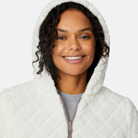 [Angelique is 5'10" wearing size S.] Light brown quilted reversible jacket with fleece-lined hood, zip front, and pockets; worn over grey shirt and blue pants.