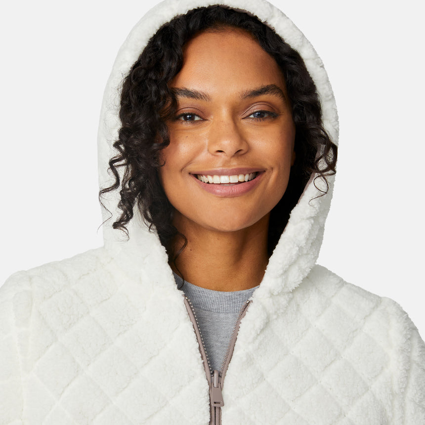 [Angelique is 5'10" wearing size S.] Light brown quilted reversible jacket with fleece-lined hood, zip front, and pockets; worn over grey shirt and blue pants.