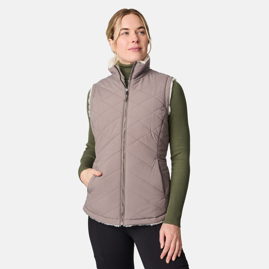 [CJ is 5'10" wearing size S.] Woman wearing a tan quilted vest on a white background