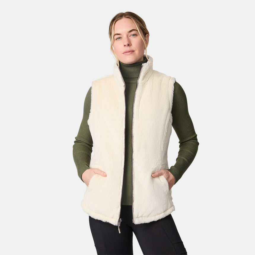 [CJ is 5'10" wearing size S.] Woman wearing a cream vest over a green sweater on a white background