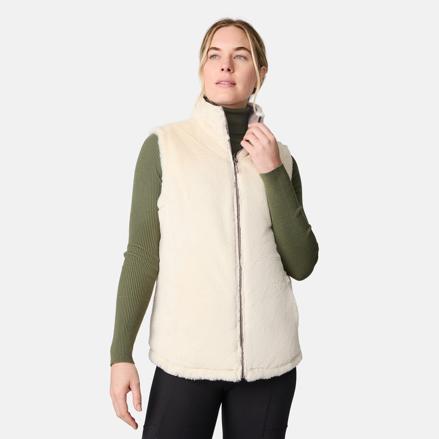 [CJ is 5'10" wearing size S.] Woman wearing a cream-colored vest over a green sweater on a white background