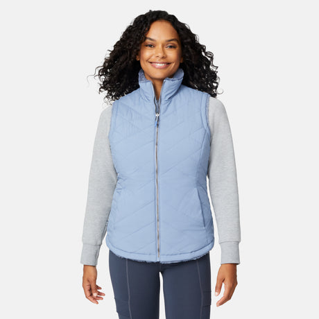 [Angelique is 5'10" wearing size S.] Woman wearing a light blue puffer vest over a gray long-sleeve shirt on a white background