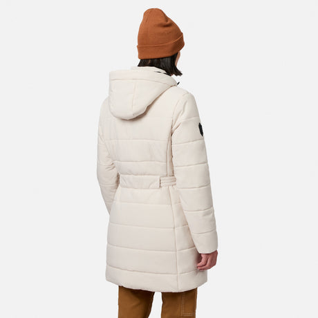 Back view of a person wearing a cream-colored Free Country Women’s Cirrus Quilted Long Puffer Jacket, featuring a water-resistant, long, hooded quilted design with a belted waist.