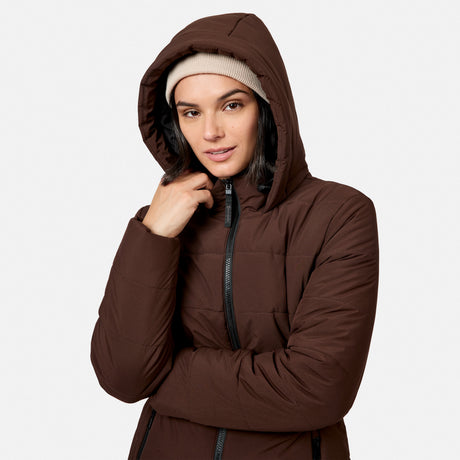 A person wearing a brown Women’s Cirrus Quilted Long Puffer Jacket with REPREVE insulation and a beige beanie.