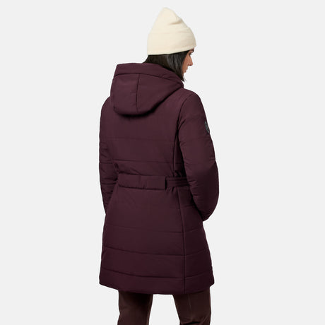 Back view of a person wearing a deep burgundy Free Country Women’s Cirrus Quilted Long Puffer Jacket with REPREVE insulation and a cream-colored beanie.