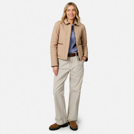 [Model is wearing size S.] A woman modeling a light tan quilted jacket, beige pants, a blue shirt, and brown shoes against a plain light gray background.