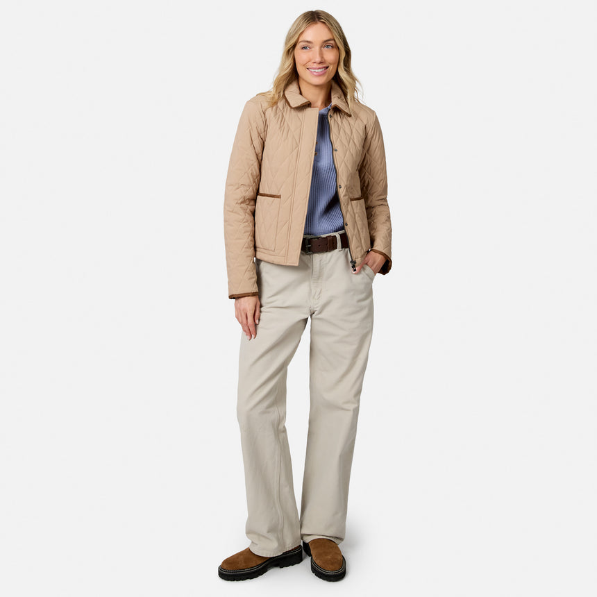 [Model is wearing size S.] A woman modeling a light tan quilted jacket, beige pants, a blue shirt, and brown shoes against a plain light gray background.
