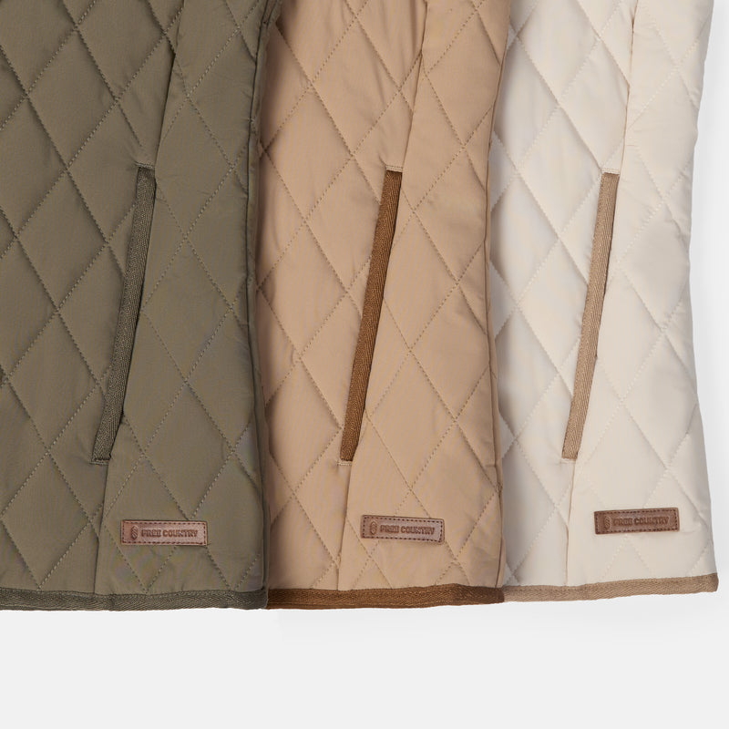 Three quilted puffer vests shown side by side in olive green, tan, and cream, each with a diagonal zip pocket and a small brown brand patch near the bottom.