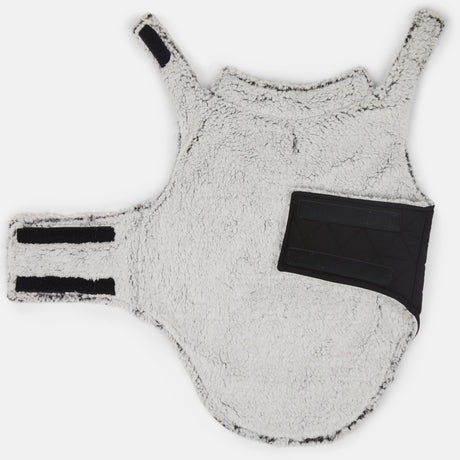 The Stratus Lite Reversible Dog Jacket by Clearance is a white, fluffy sherpa-lined coat featuring black Velcro straps and a rectangular black pocket on one side, shown laid flat on a white background.