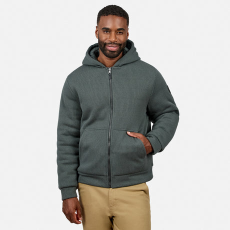 Front view of a man wearing the dark green Chayote Cable Fleece Reversible Jacket with hood up.