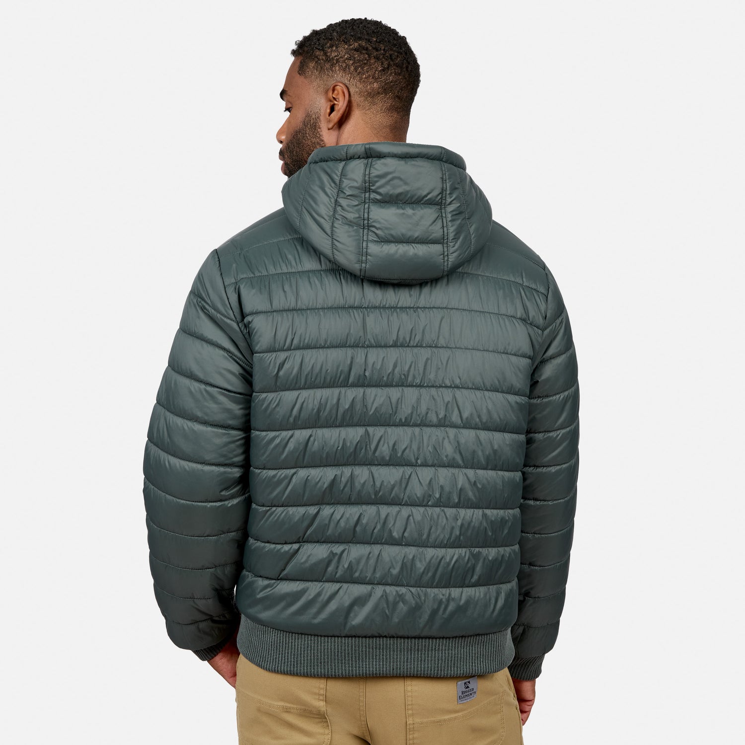 Back view of a man wearing a teal quilted hooded jacket.
